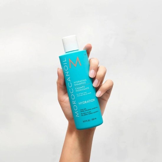 Turquoise Moroccanoil Hydrating Shampoo fles van 8.5 FL.OZ. / 250 ml met witte dop en oranje logo op een lichte achtergrond.