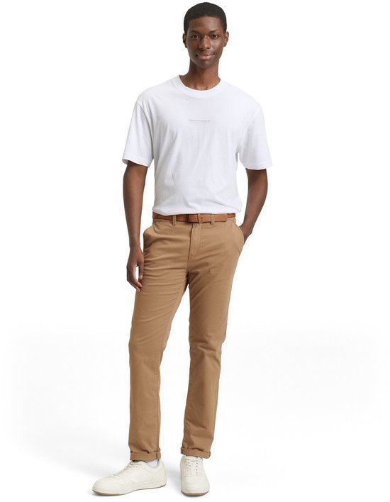 Man met bruine chino broek en witte t-shirt.