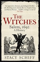 Boekcover met de titel 'The Witches Salem, 1692 A History' door Stacy Schiff. Illustratie van een duivel met vleugels en hoorns die baby's aanbiedt aan geklede figuren.