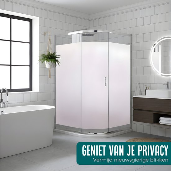 Een moderne badkamer met een vrijstaand bad en een douchecabine met matglas. Raamfolie zorgt voor privacy.