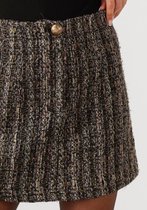 Gros plan de la ceinture d'une jupe courte en tweed texturé noir avec des accents bruns et dorés. Fermeture par bouton visible.