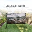 Projectiescherm met bergenafbeelding, opgesteld in een tuin met gras en houten schutting. Inclusief grondpinnen en touwen voor stabiliteit.