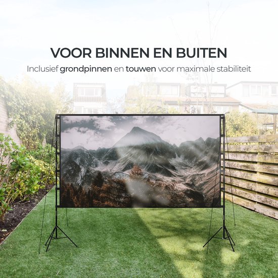 Projectiescherm met bergenafbeelding, opgesteld in een tuin met gras en houten schutting. Inclusief grondpinnen en touwen voor stabiliteit.