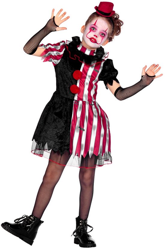 Enfant déguisée en clown : robe noire et rayée rouge et blanc, pompons rouges, bas résille, chaussures montantes, chapeau rouge.
