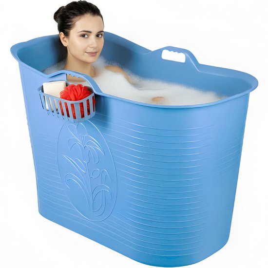 Vrouw zit in een schuimend, blauw draagbaar bad met opbergmandje. Bad heeft reliëf en bloemmotief.