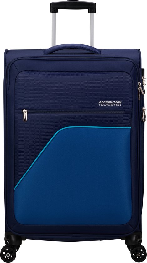 Donkerblauwe koffer met een diagonaal vak in helderblauw en een turquoise accent. "American Tourister" logo zichtbaar.