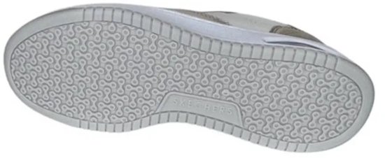 Onderkant van een witte sneaker met een beige zool met een repetitief schakelpatroon en 'Skechers' logo.