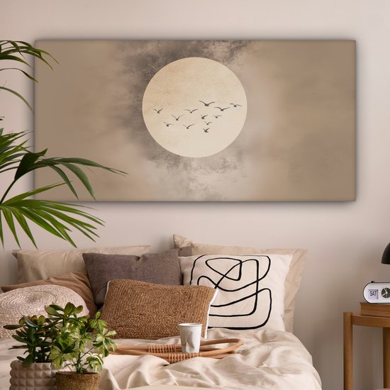 Canvas met beige achtergrond, zachte cirkel, zwerm vogels, in een slaapkamer met veel kussens.