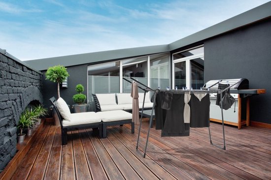 Zwart droogrek met kleding op een houten terras, met loungeset en barbecue.