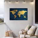 Carte du monde dorée sur fond bleu foncé, accrochée à un mur blanc sur un balcon avec des chaises.