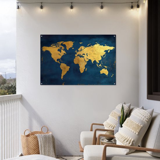 Carte du monde dorée sur fond bleu foncé, accrochée à un mur blanc sur un balcon avec des chaises.