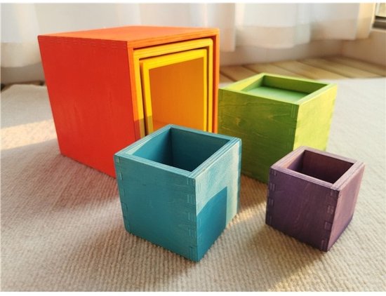 Houten stapelbare kubussen in regenboogkleuren, deels uit elkaar gehaald: groot rood, geel, groen, blauw en paars.