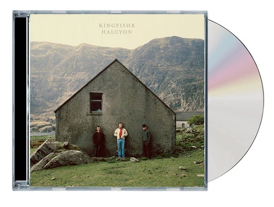 CD-hoes van "Halcyon" van Kingfishr. Drie mannen staan voor een stenen huis met bergen op de achtergrond. De CD ligt ernaast.