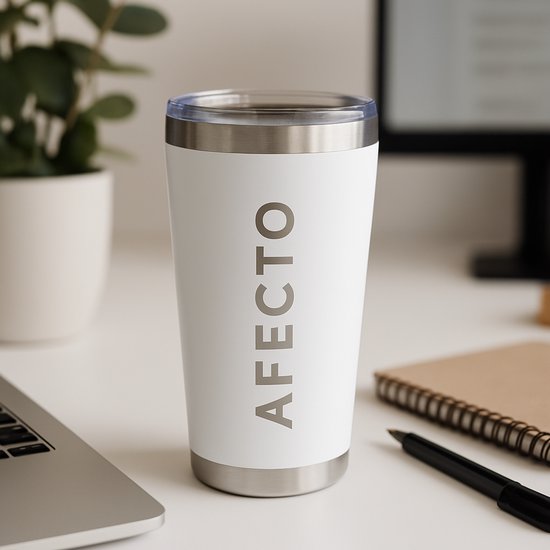 Witte Afecto beker met zilverkleurige randen op een bureau, naast een laptop.