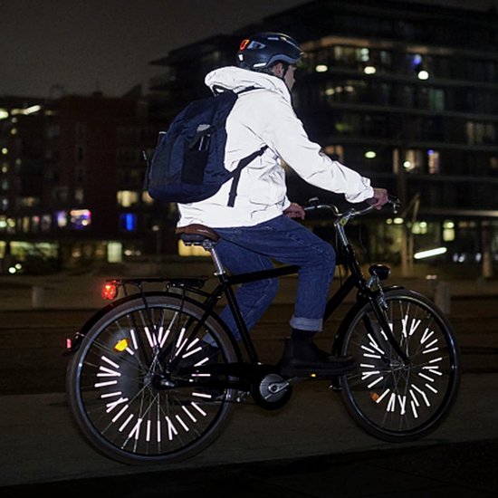 Fietser 's nachts op een fiets met reflecterende spaken en jas.