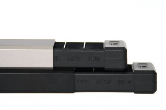 Twee pillendoosjes, één zwart en één grijs aluminium, met dagen van de week erop.