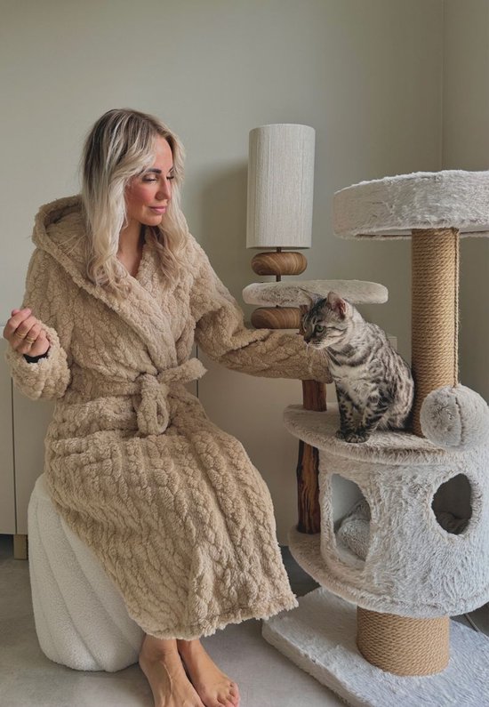 Lange beige badjas met capuchon van zacht fleece, gedragen door een vrouw met een kat.