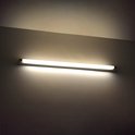 Een TL-lamp aan een muur verlicht de ruimte met een warm, geel licht.