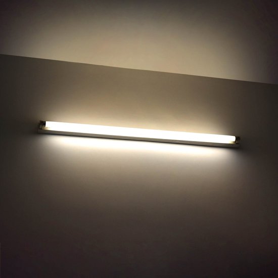 Een TL-lamp aan een muur verlicht de ruimte met een warm, geel licht.