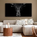Toile noir et blanc avec un gros plan d'une tête de taureau, placée sur un fond sombre.
