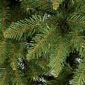 Detailopname van groene kunstkerstboomtakken met bruine accenten.