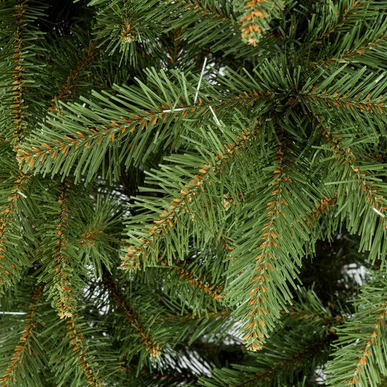 Detailopname van groene kunstkerstboomtakken met bruine accenten.