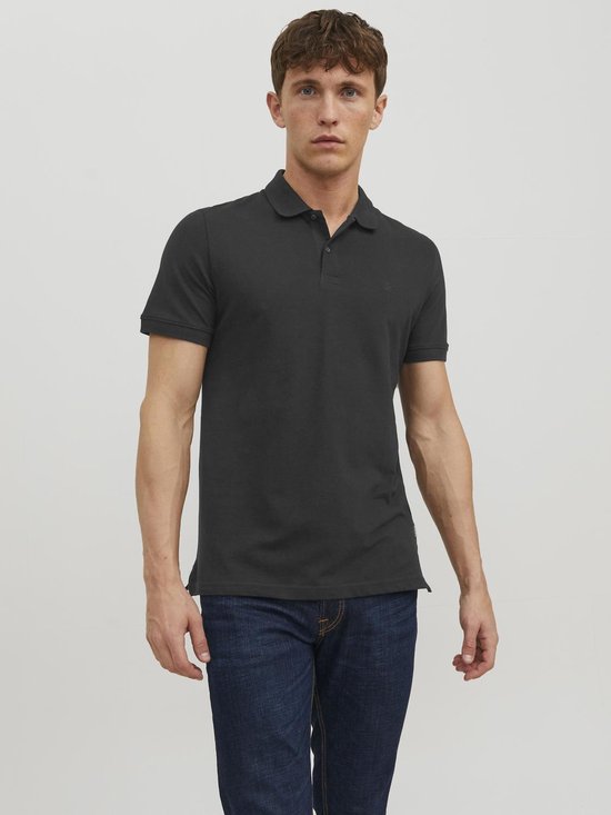Grijze polo met korte mouwen, kraag en knoopjes. Model draagt spijkerbroek.