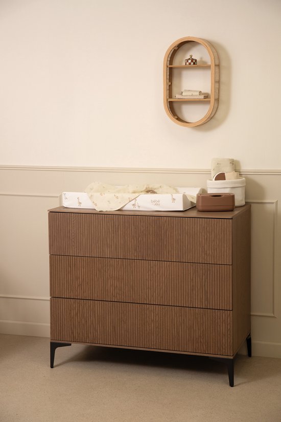 Een commode met een aankleedkussen met ganzenprint. Op de commode staan verzorgingsproducten.