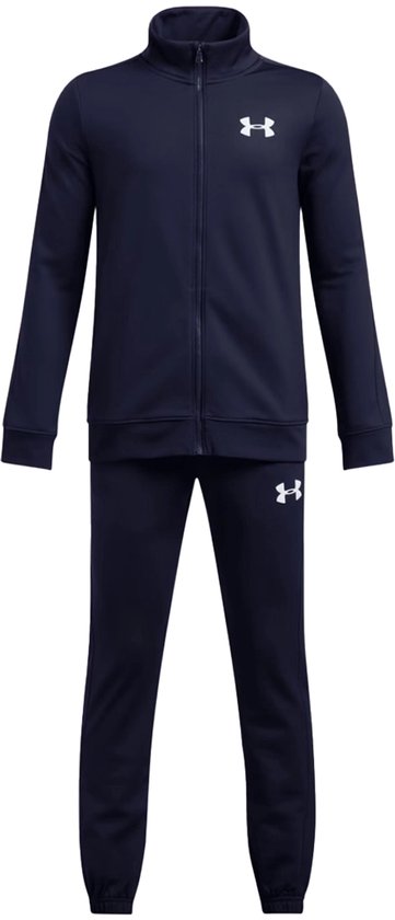 Donkerblauwe trainingspak met witte Under Armour logo's op de borst en linkerbroekspijp. Trainingsjack met hoge hals en lange mouwen, trainingsbroek met lange mouwen.