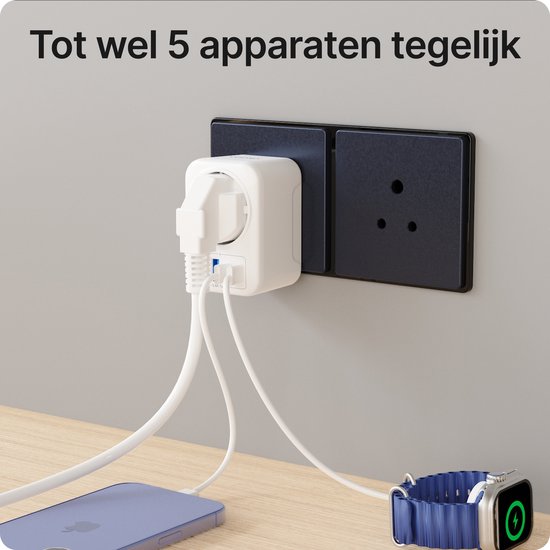 Witte reisstekker aangesloten op een stopcontact, laadt een telefoon en een smartwatch op.