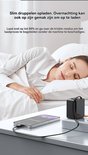Een vrouw slaapt in bed, naast een telefoon die oplaadt via een zwarte compacte oplader op een nachtkastje.