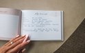 Een open kraamvisiteboek met handgeschreven tekst. De rechterpagina bevat het formulier 'Mijn kraamvisite' met velden voor datum en naam. De linkerpagina is ook gevuld.