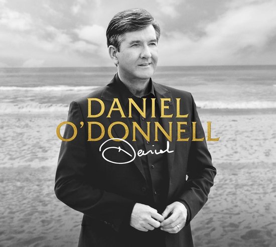 Daniel O'Donnell staat op een strand met de tekst DANIEL O'DONNELL.