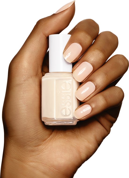Donkere hand houdt een flesje Essie nagellak vast met bijpassende nagels.