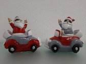 2 beeldjes van een kerstman in een auto
