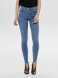 Model in een lichtblauwe skinny jeans en zwarte puntlaarzen.