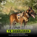 Bruine Mechelse herder met beige tuigje, lijn en flexibele riem in een groene omgeving.