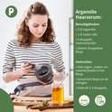 Een vrouw met krullend bruin haar die kruiden in een vijzel maalt in een keuken.
