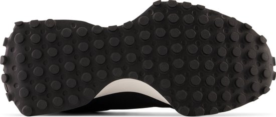 Zool van een zwarte New Balance 327 sneaker met nopjes.