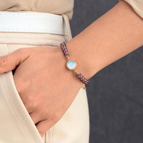 Gevlochten armband met paarse amethist kralen en een ronde, witte Marly Quartz steen, gedragen op een pols.