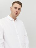 Man met blauwe ogen draagt een wit Jack & Jones overhemd.