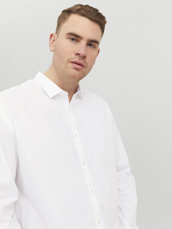 Man met blauwe ogen draagt een wit Jack & Jones overhemd.