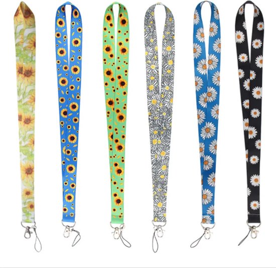 Zes lanyards met bloemenpatronen: zonnebloemen op geel, zonnebloemen op blauw, zonnebloemen op groen, madeliefjes op grijs, madeliefjes op blauw, madeliefjes op zwart.