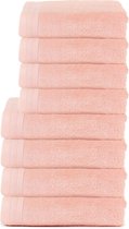 Stapel van acht roze handdoeken op een witte achtergrond.