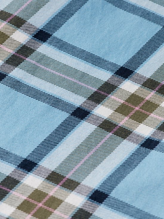 Detail van een lichtblauwe geruite stof met strepen in wit, donkerblauw, olijfgroen en lichtroze.