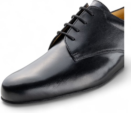 Gros plan sur une chaussure derby noire en cuir lacée avec une semelle intérieure jaune.