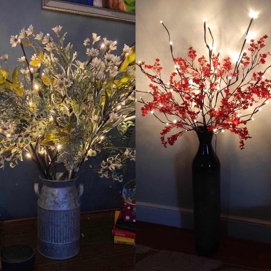 Twee decoraties: linker met groene takken met bloemen en LED's, rechter met rode takken met LED's.