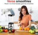 Vrolijke vrouw snijdt sinaasappels naast een Kitchenwell blender.