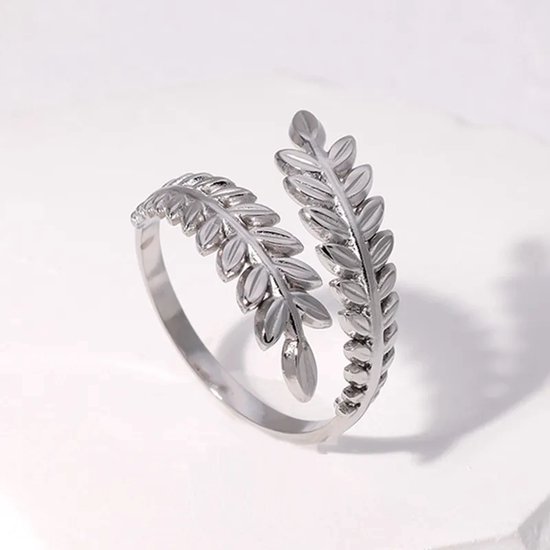 Zilverkleurige ring met een open ontwerp, versierd met twee gestileerde bladeren.