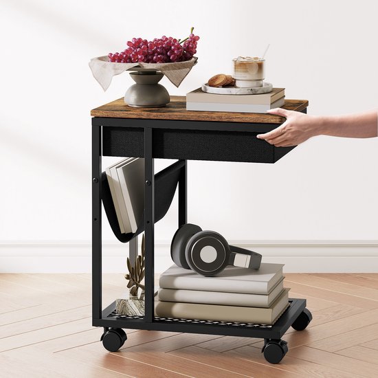 Zijtafel met houten blad, een zwarte stoffen mand, een metalen frame met wieltjes en een netwerkplank. Gevuld met boeken en een koptelefoon.